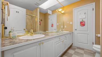 A bathroom with two sinks, a large mirror, and a toilet.