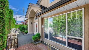 A house with a large window, a stone statue, and a brick pathway. - Charming Family Hotel (Richmond)