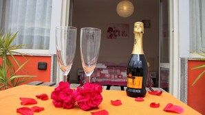 A table with a bottle of champagne, two glasses, and rose petals. - B&B Zefiro (Pompei)