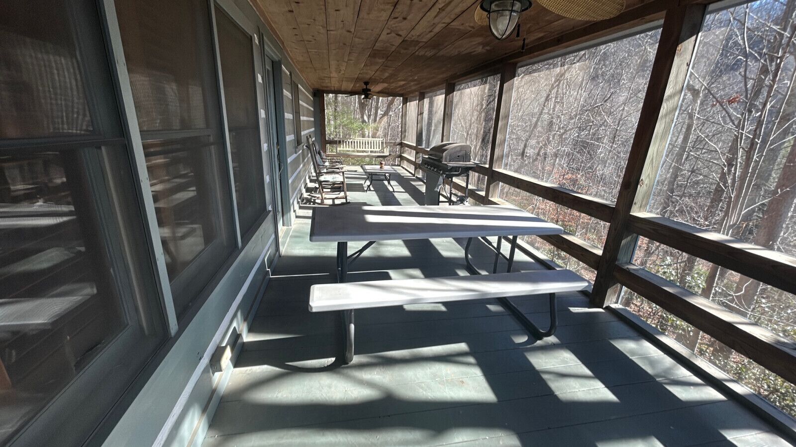 An outdoor covered patio with picnic tables and a grill.