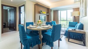Un comedor moderno con una mesa redonda, sillas tapizadas en azul y una lámpara de araña.