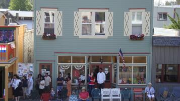 Un bâtiment à deux étages doté d’une devanture, d’une terrasse et d’un drapeau.