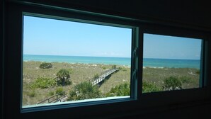 A window with a view of a beach and a wooden boardwalk. - Beachfront - Romantic - Relaxing - Panoramic Views - Little Gasparilla Island  (Placida)