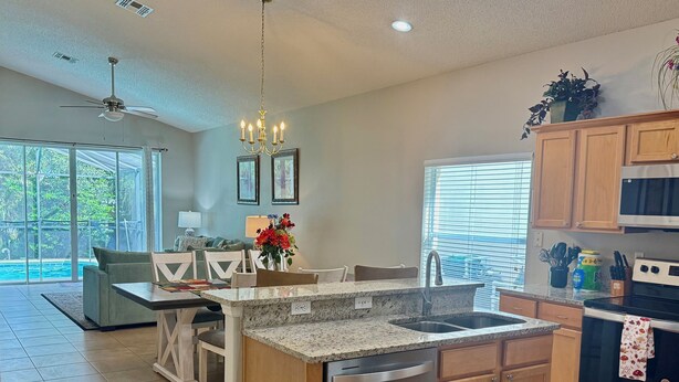 A modern kitchen with granite countertops, stainless steel appliances, and wooden cabinets.