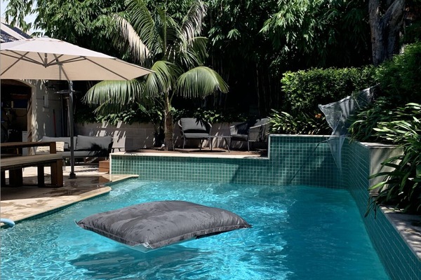 Outdoor pool & dining area surrounded by lush bamboo