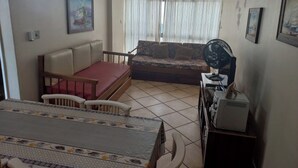 Un soggiorno con divano, tavolo da pranzo e ventilatore a soffitto.