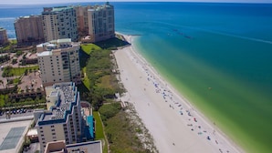 Ein Küstenhotel mit mehreren Hochhäusern, einem Sandstrand und freiem Blick auf den Ozean.