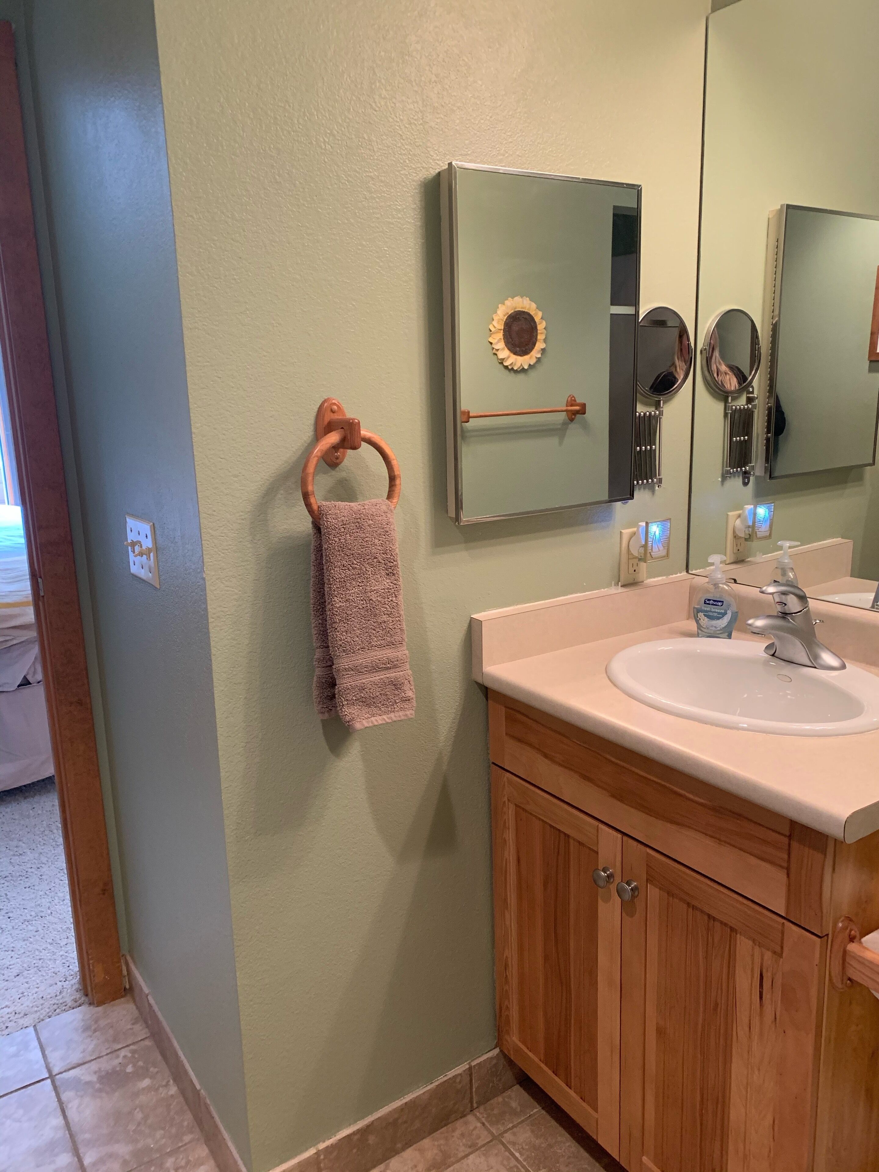 A bathroom with a wooden vanity, a sink, and a mirror.