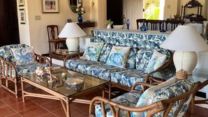 A spacious living room with a large sofa set, a glass coffee table, and a dining area with a wooden table and chairs. - SPACIOUS PRIVATE PARADISE FOR NATURE LOVERS - An extraordinary vacation rental! (Kingshill PO)