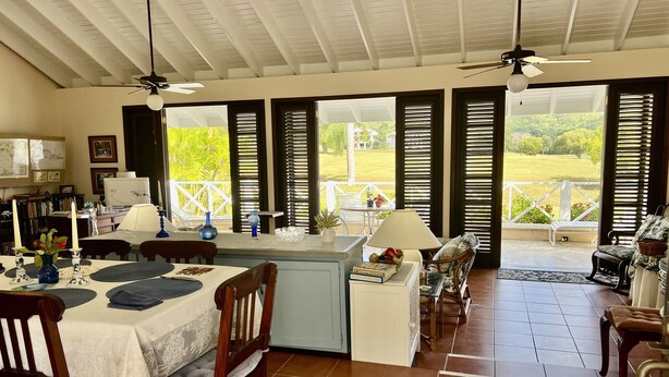 A spacious dining area with a high ceiling, large windows with shutters, and a view of the outdoors. - SPACIOUS PRIVATE PARADISE FOR NATURE LOVERS - An extraordinary vacation rental! (Kingshill PO)