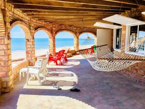 A beachside patio with brick arches, white and red chairs, a hammock, and a view of the ocean. - Promo - Awesome  -Beach Front Villa on Sandy Beach  - Hi Speed Wi-Fi (San Felipe)