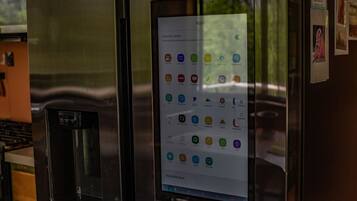 Un réfrigérateur doté d’un écran numérique affichant la liste des applications disponibles.
