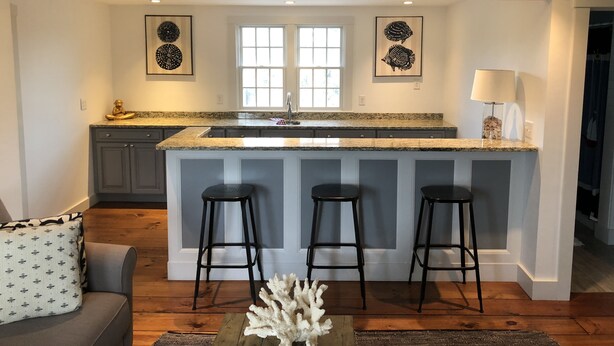 Una cocina con una isla central, taburetes de bar y un letrero que dice "The Horny Whale".