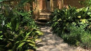 A brick building with a gravel pathway leading to a door.