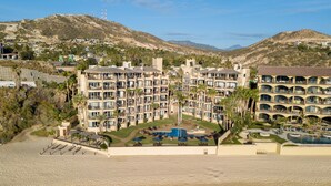 Un hôtel doté de nombreux balcons, d’une piscine et offrant une vue sur les collines environnantes.
