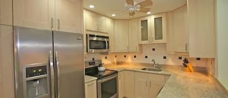 Enjoy cooking in this well-equipped kitchen with a refrigerator, microwave, and oven, as well as a water dispenser.