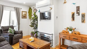 A modern living room with a sofa, a wooden coffee table, a fireplace, and decorative wall art. - Olinda Two Bedroom Apartment B2 - This beautiful and comfortably furnished apartment is centrally located in the village of Olinda. (Olinda)