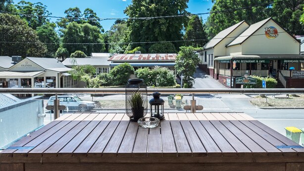 A wooden deck with a view of a town, including a restaurant and cafe. - Olinda Two Bedroom Apartment B2 - This beautiful and comfortably furnished apartment is centrally located in the village of Olinda. (Olinda)