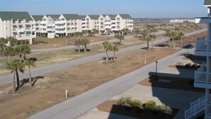 Un hôtel à plusieurs étages doté d’un toit végétalisé, d’un parking et offrant une vue sur la plage.