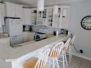 Island with barstools overlooking kitchen