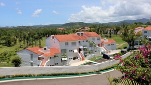 A residential area with modern buildings, a well-maintained lawn, and a clear view of distant mountains. - Rio Mar Beach Resort - Time Magazine TOP 100 World's Greatest Places  2018 (Rio Grande)