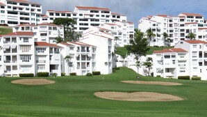 A golf course with bunkers and a backdrop of white residential buildings with red roofs. - Rio Mar Beach Resort - Time Magazine TOP 100 World's Greatest Places  2018 (Rio Grande)