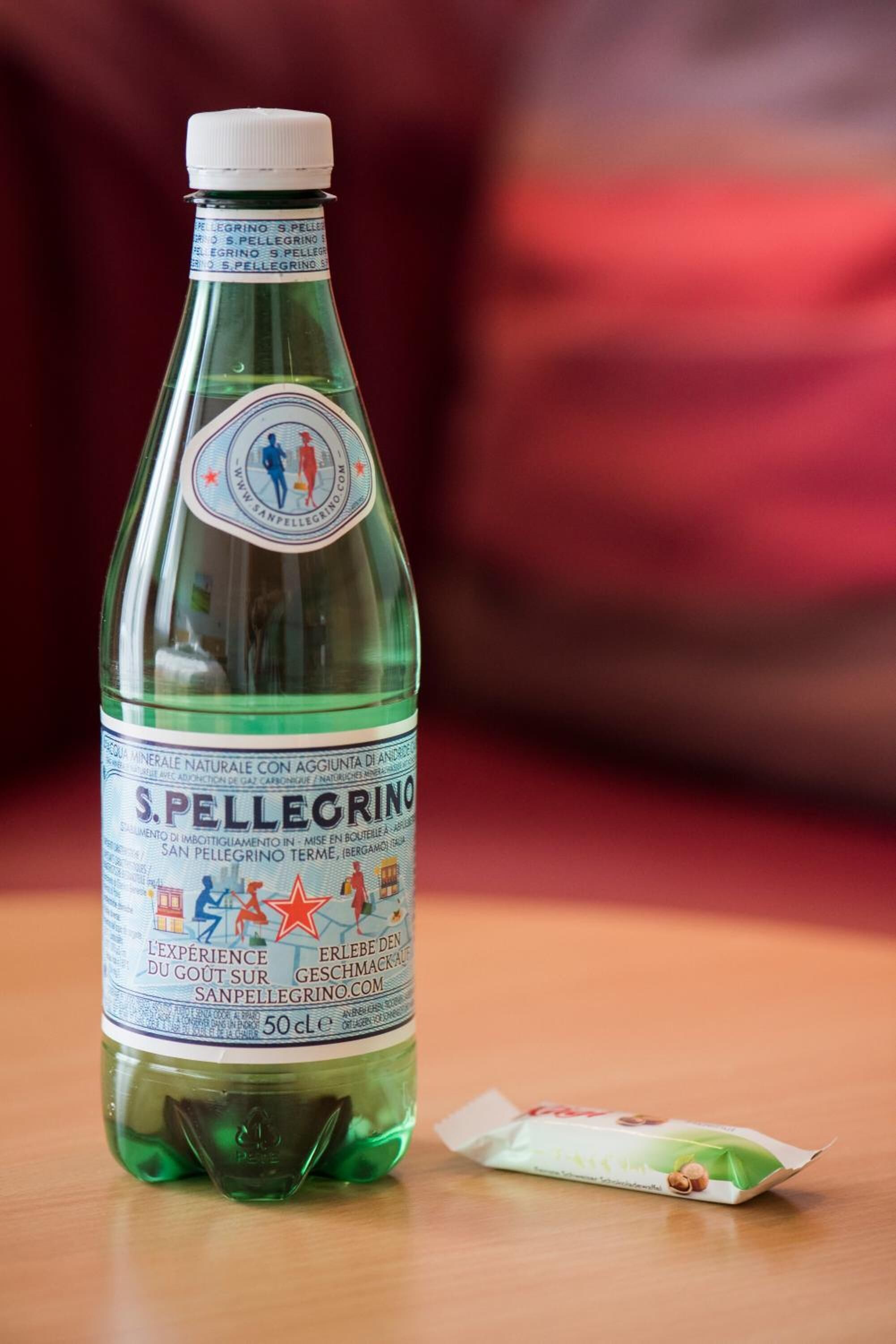 Une bouteille d’eau pétillante S. Pellegrino et un paquet de collations.
