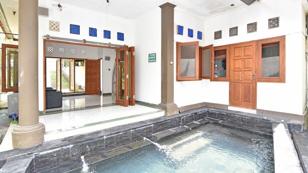 Ein Wellnessbereich mit Whirlpool, Holztüren und Fliesenboden.