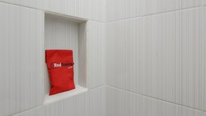 A white tiled wall with a red bag hanging in a corner. - RedDoorz near Central Park Mall (Jakarta)