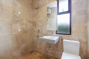 Une salle de bain avec un lavabo, un miroir et des toilettes.