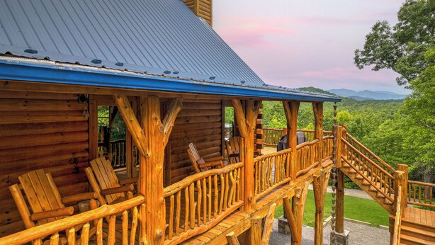 Eine Holzhütte mit blauem Dach, einer Holzdiele und einer Treppe, die zu einer Veranda führt.