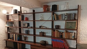 Uma estante de madeira com diversos objetos, incluindo livros, um rádio e itens decorativos.