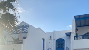 A building with a white exterior, blue accents, and a tiled staircase.