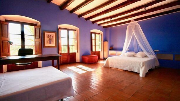 Ein Schlafzimmer mit einem Bett, einer Bank und einem Schreibtisch.