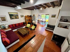 A living room with a sofa, chairs, a coffee table, a fireplace, and a dining area with a table and chairs.