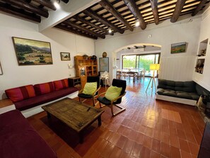 A living room with a red sofa, a wooden coffee table, and a dining area with a table and chairs.