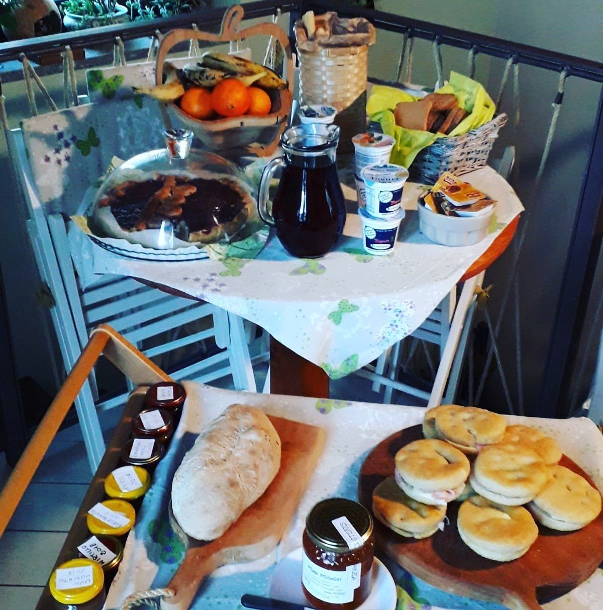 Une table dressée avec divers aliments, notamment du pain, des pâtisseries et des condiments.