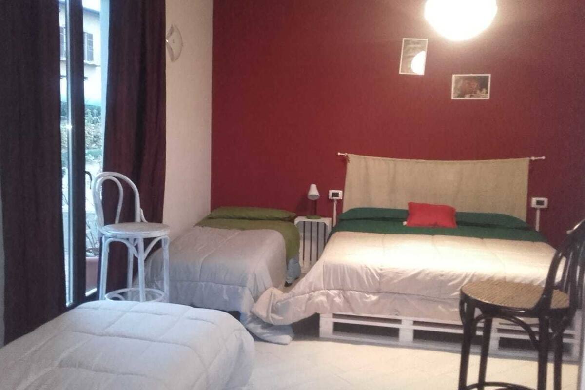 A room with two beds, a chair, and a radiator.