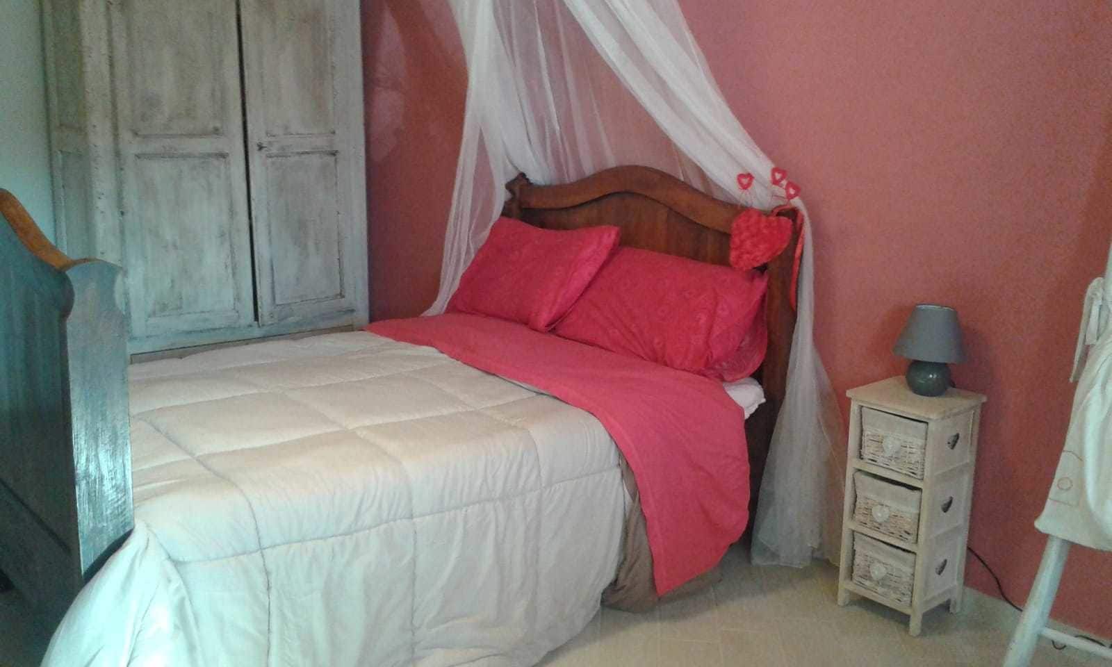 Ein Schlafzimmer mit einem Bett, einem Nachttisch, einer Lampe und einem Kleiderschrank.