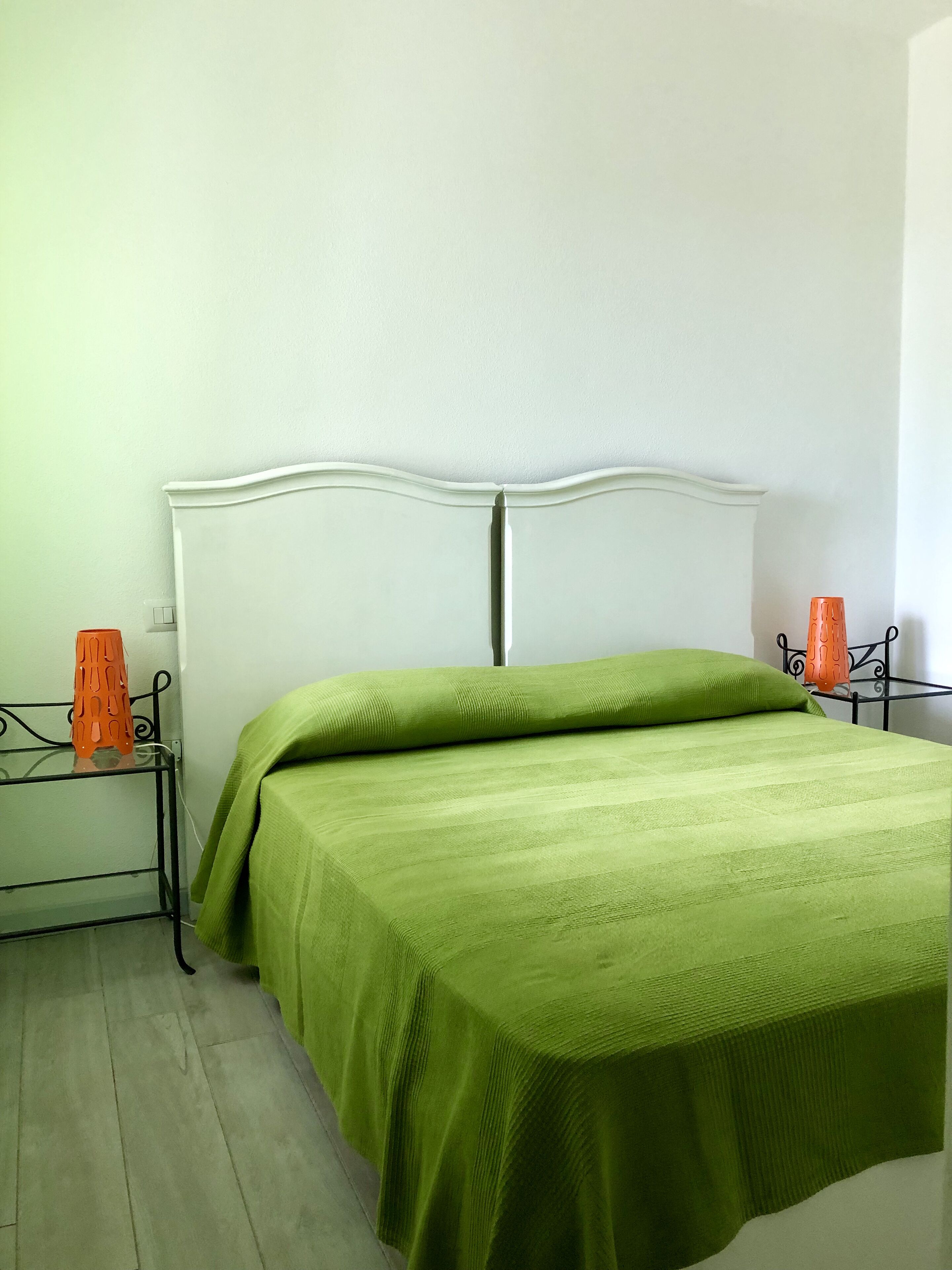 Ein Zimmer mit einem Bett, einem Nachttisch und einem Stuhl.