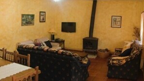 Una sala acogedora con sofá, mesa de comedor y televisor.