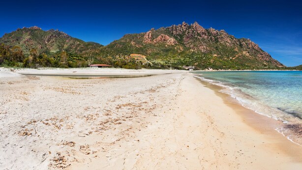 A beach with clear turquoise water, a sandy shore, and a mountain in the background. - Villa "The lapwing one" (semi-detached portion of the sea) (Marina di Tertenia, Tertenia (OG))