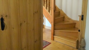 A wooden staircase with a handrail leading to an upper floor. - Character 2 bedroom barn conversion in peaceful rural setting (Norwich)