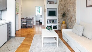 A modern living room with a white sofa, a white coffee table, and a stone accent wall.