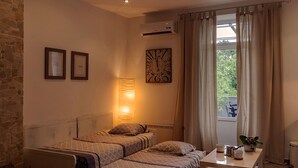 A bedroom with a bed, bedside table, lamp, and a window with curtains.