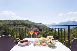 A table set with food and drinks on a balcony with a mountain view. - Family friendly Italian Lakes villa rental (Dumenza)
