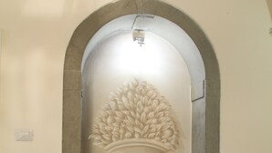 Scultura a parete raffigurante un vaso con foglie.