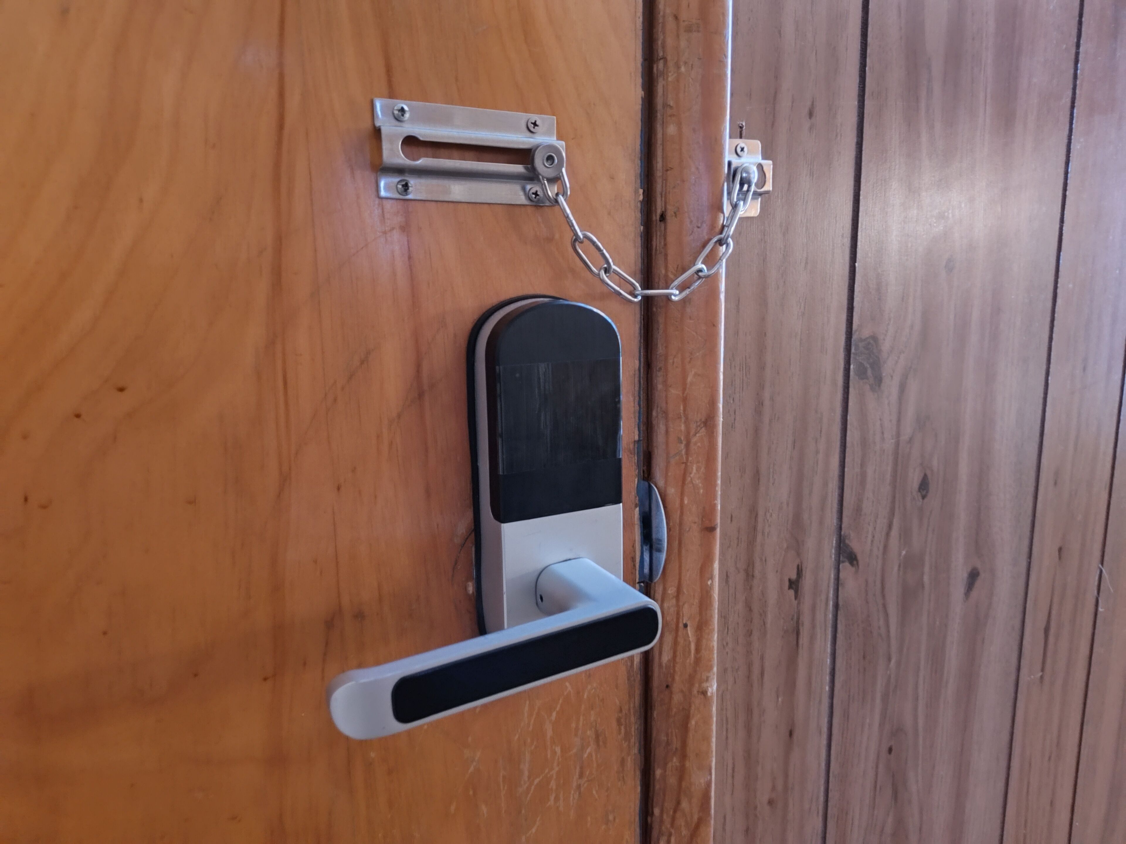 Una puerta con un ojo de cerradura, un cerrojo y un picaporte.