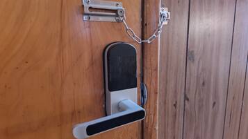 Una puerta con un ojo de cerradura, un cerrojo y un picaporte.