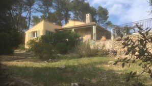A two-story house with a stone wall and a metal fence. - SUPERB SECLUDED VILLA WITH STUNNING VIEWS AND HEATED SWIMMING POOL 
 (Saint-Antonin-Du-Var)